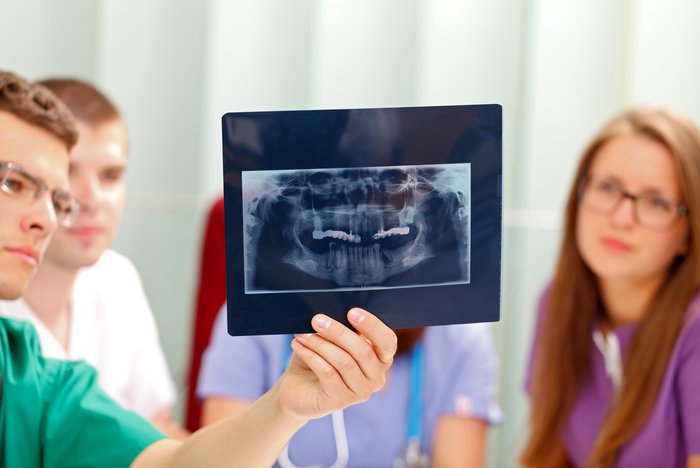 Doctor examining dental xray - dental scenarios requiring a medical suction machine