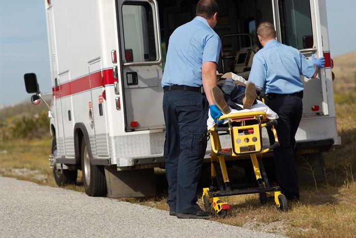Two EMTs putting a patient into ambulance | why include a portable suction pump in your pedi bag?
