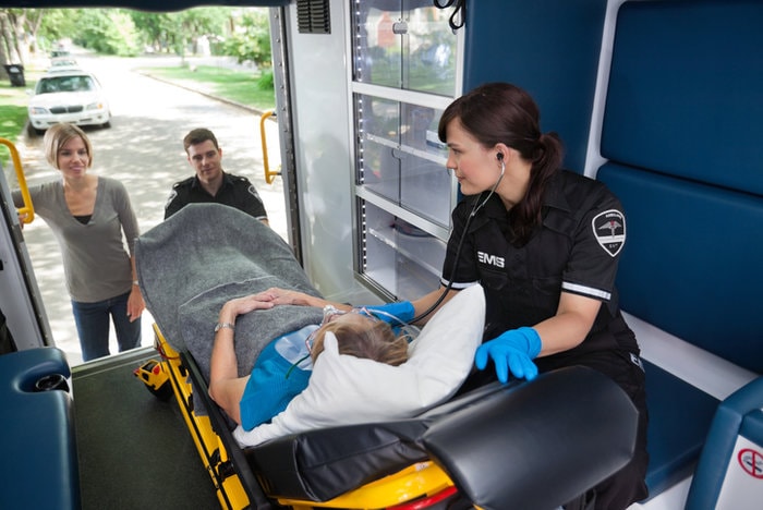 Paramedic treating patient on stretcher in an ambulance