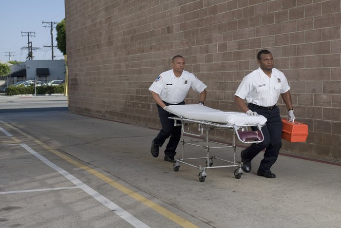 Paramedics rushing to scene with stretcher and respiratory emergency devices