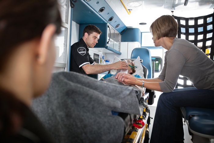 Patient being treated with portable suction pump on an ambulance