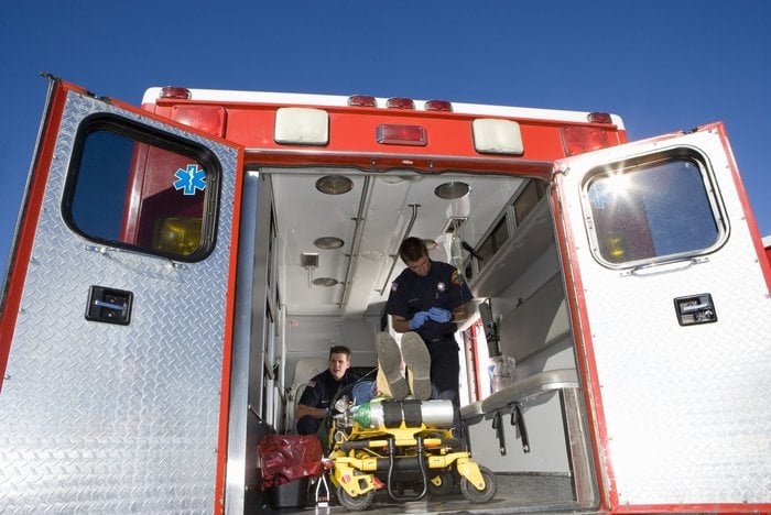 Patient being treated in ambulance - portable suction unit