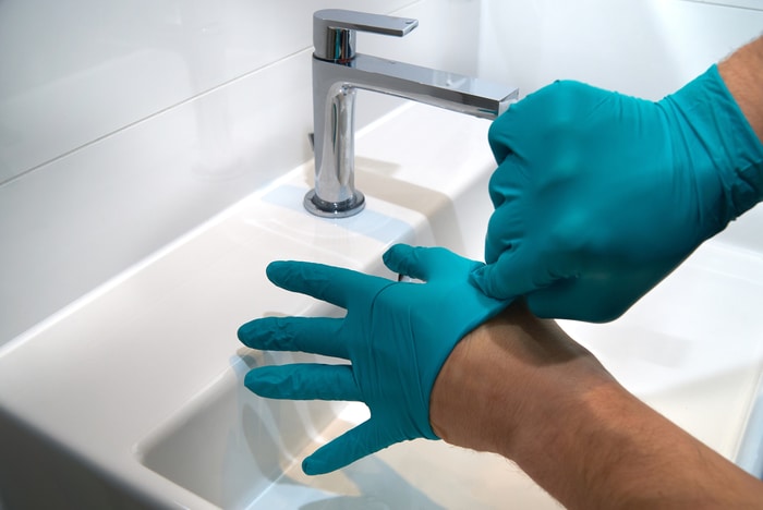 Washing hands while removing gloves - keeping your portable medical suction unit healthy